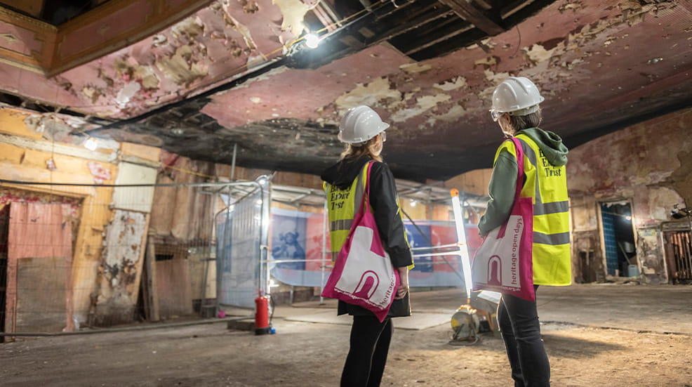 Two people exploring derelict building at Heritage Open Days, sporting Heritage tote bags
